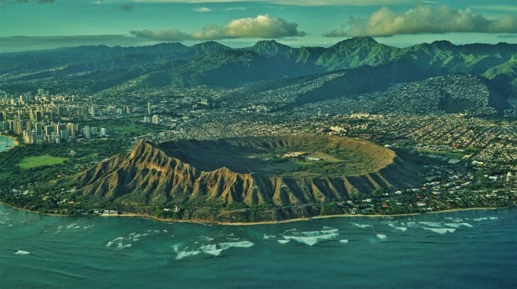 an aerial view of a crater in the ocean with Diamond Head in the background