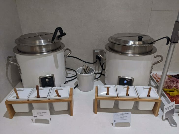 a group of large white pots with silver lids