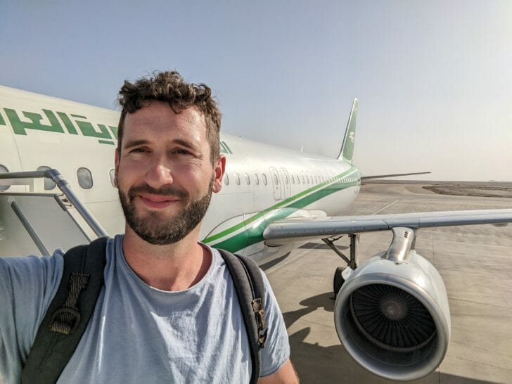a man taking a selfie in front of an airplane