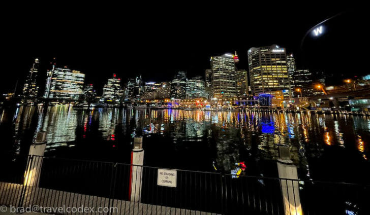 a city skyline at night with lights reflecting on water