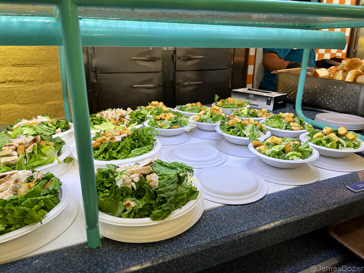 a group of plates of salad on a counter
