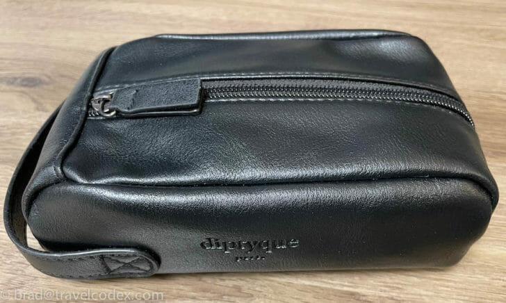 a black leather bag on a wood surface