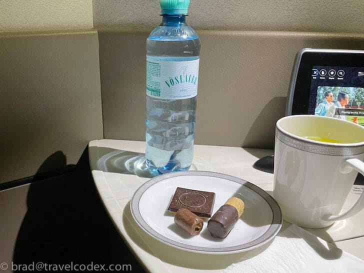 a plate of chocolate and a cup of water on a table