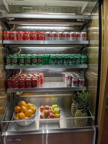 a refrigerator full of soda and fruit