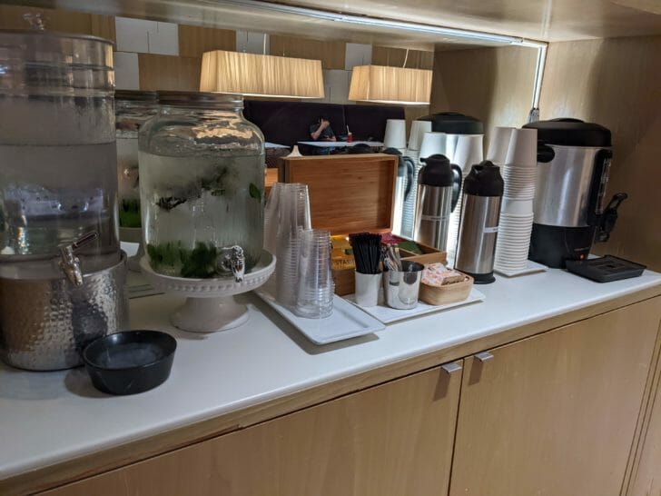 a counter with a variety of coffee cups and containers