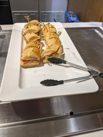 a plate of sandwiches with tongs