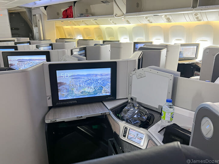 a row of seats with monitors and a bottle of water