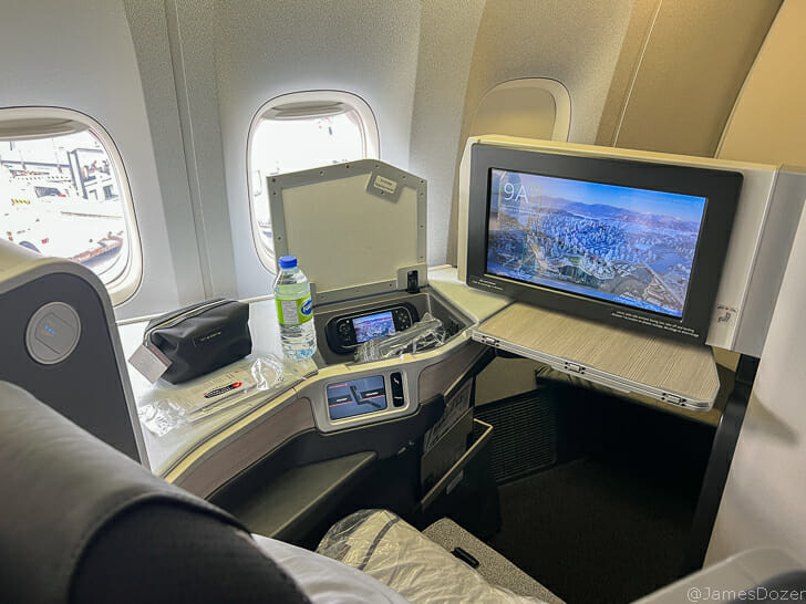 a tv and a bottle on a table in an airplane