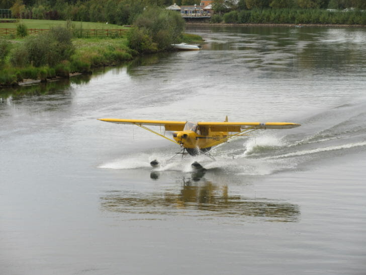 a yellow plane on a river