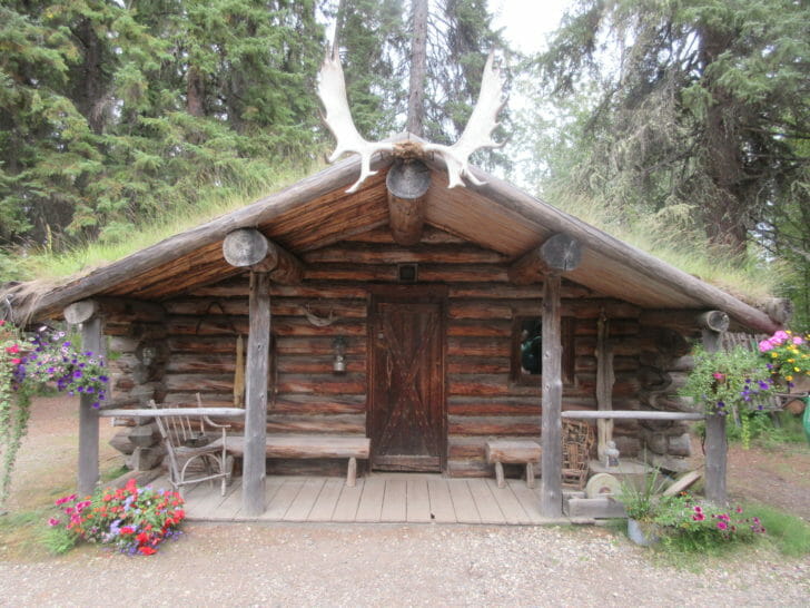 a log cabin with a grass covered roof