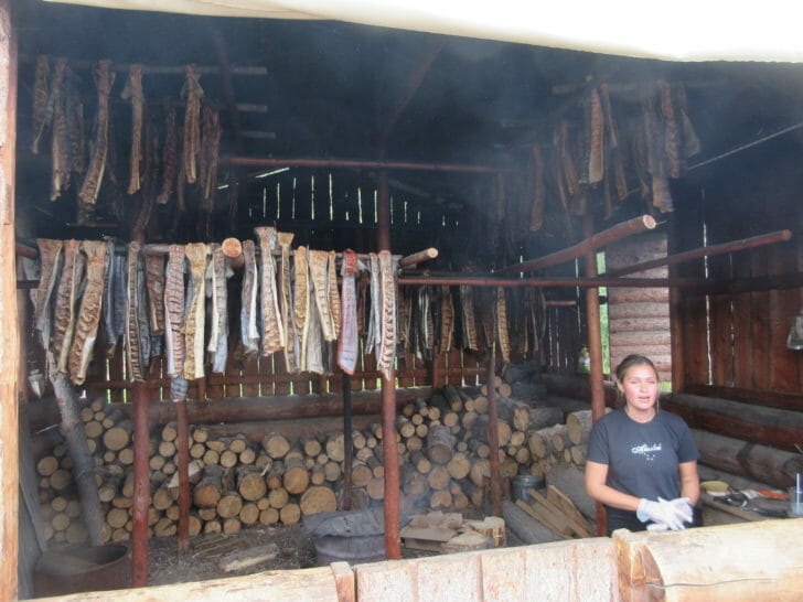 a woman standing in front of a wood shed
