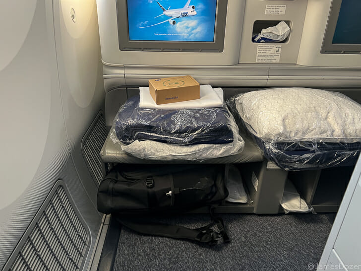 a seat with a tv and a bag on it