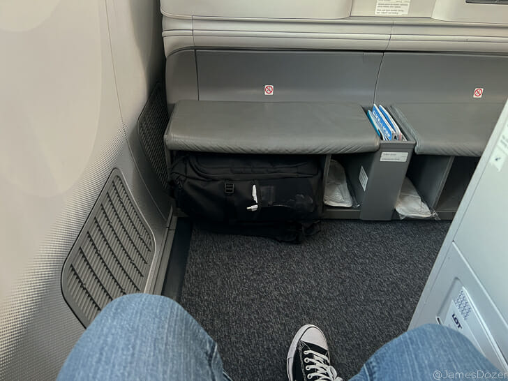 a person's legs in jeans and sneakers on a seat