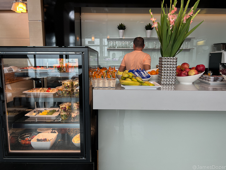 a man standing behind a counter with food in a glass case