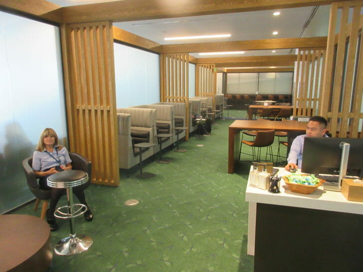 a man and woman sitting in a room with chairs and tables