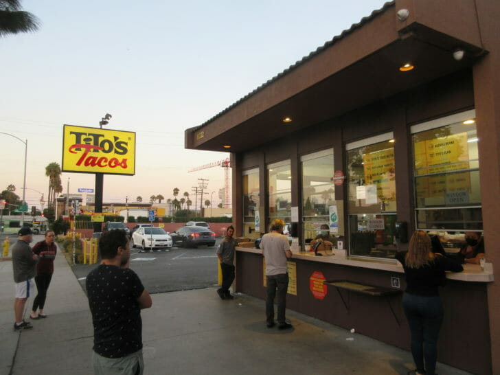 a group of people standing outside a restaurant