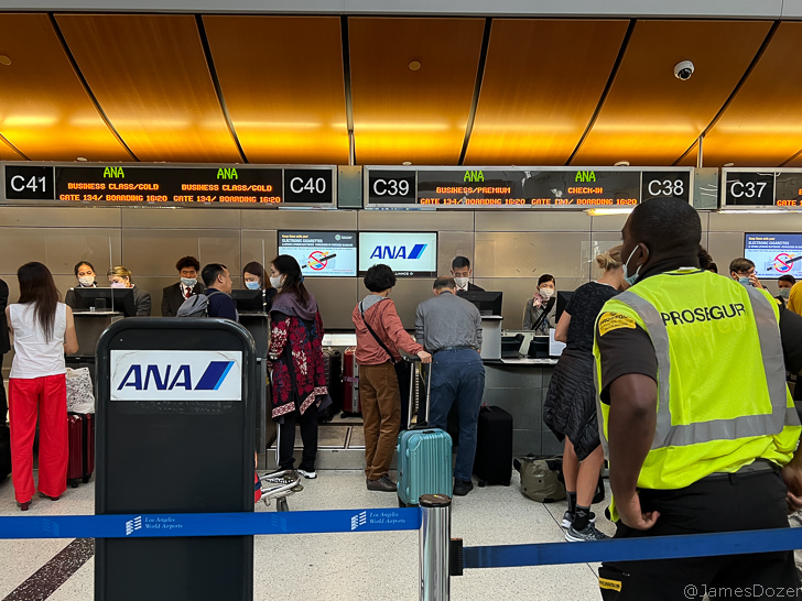 people standing in front of a line of people wearing masks