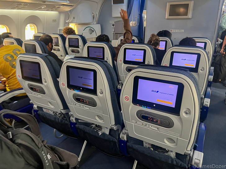 a row of seats with monitors on the back