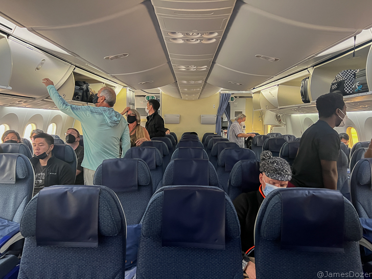 people in an airplane with people wearing face masks