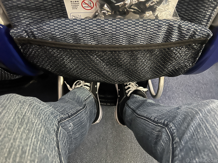 a person's legs in jeans and black shoes