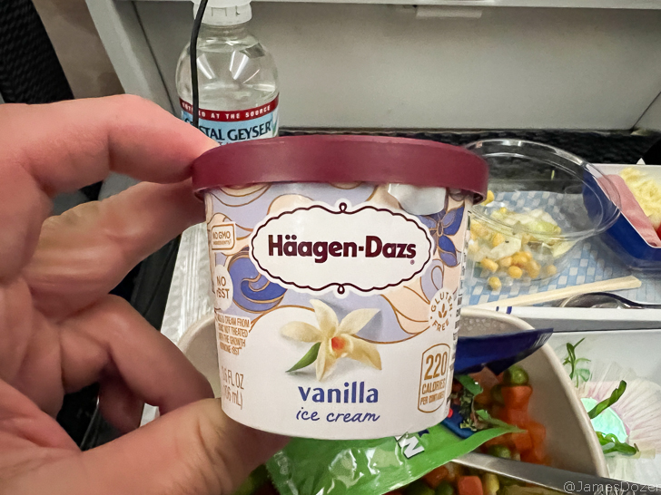 a hand holding a container of ice cream