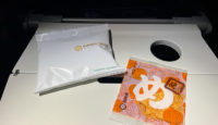 a white packet and orange packet on a white surface