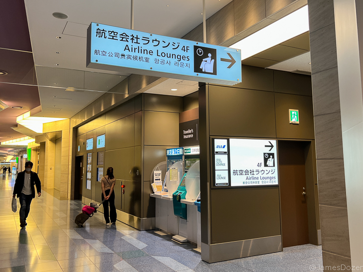 a woman standing in a hallway with a luggage bag