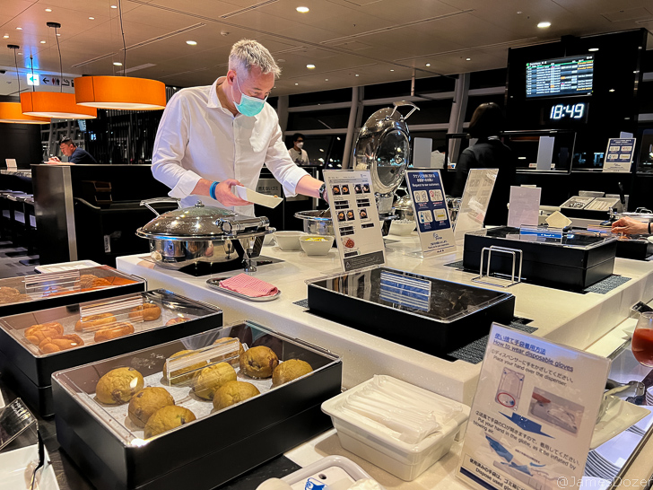 a man wearing a mask at a buffet