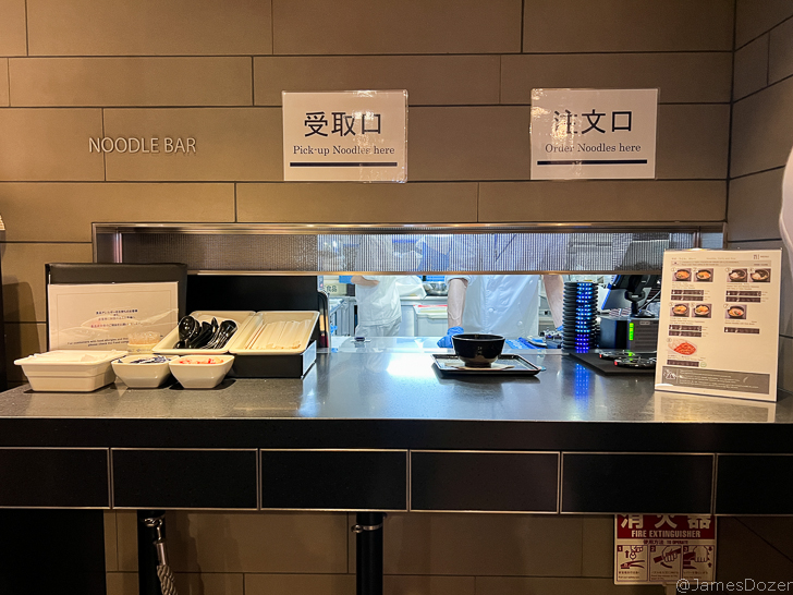 a noodle bar with bowls and bowls on a counter