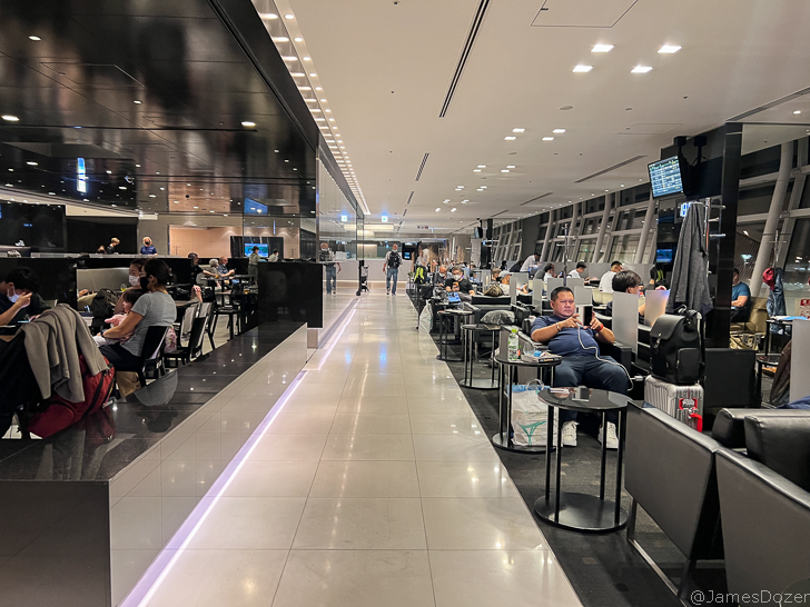 people sitting at tables in a room with computers