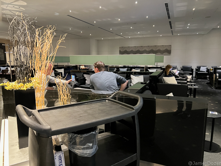 a group of people sitting in a room with chairs and a table