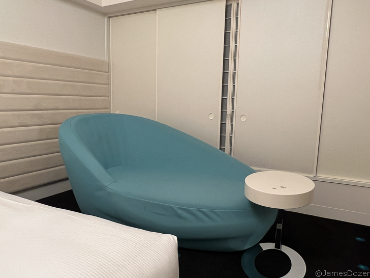 a blue chair next to a white table