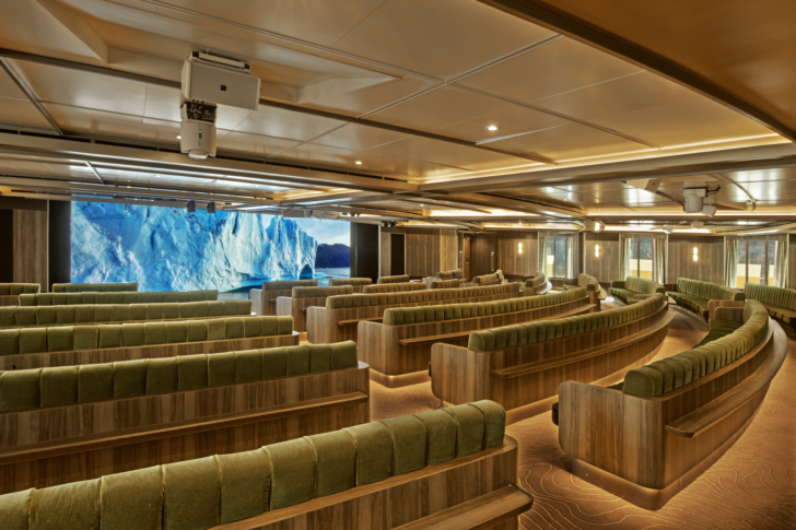 a room with green seats and a view of an iceberg