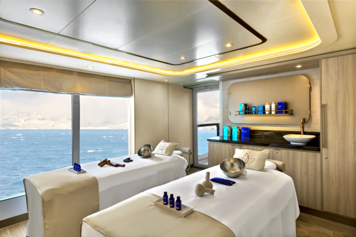a room with massage beds and a view of the ocean