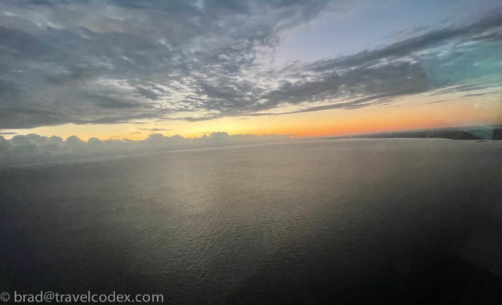a body of water with clouds and a sunset
