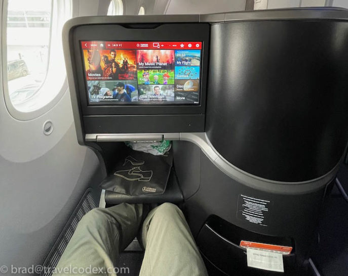 a person's legs in a chair with a television screen