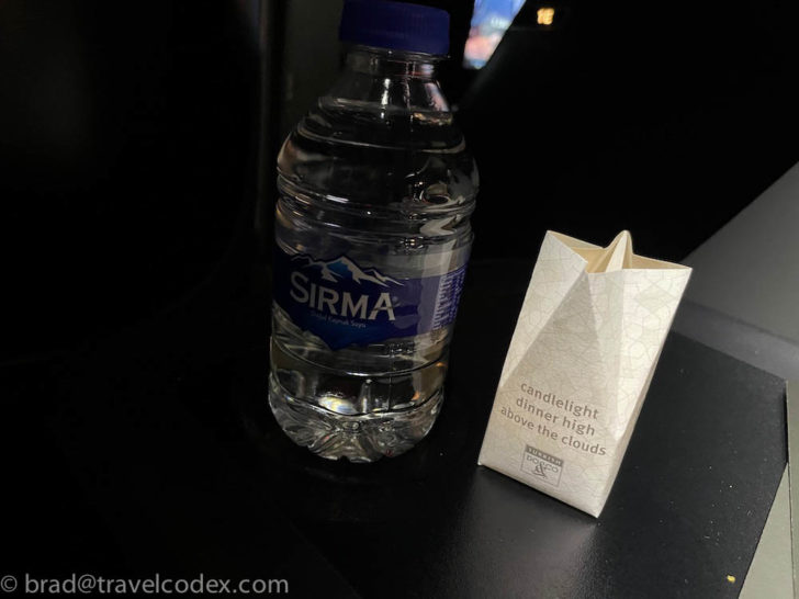 a bottle of water next to a paper bag