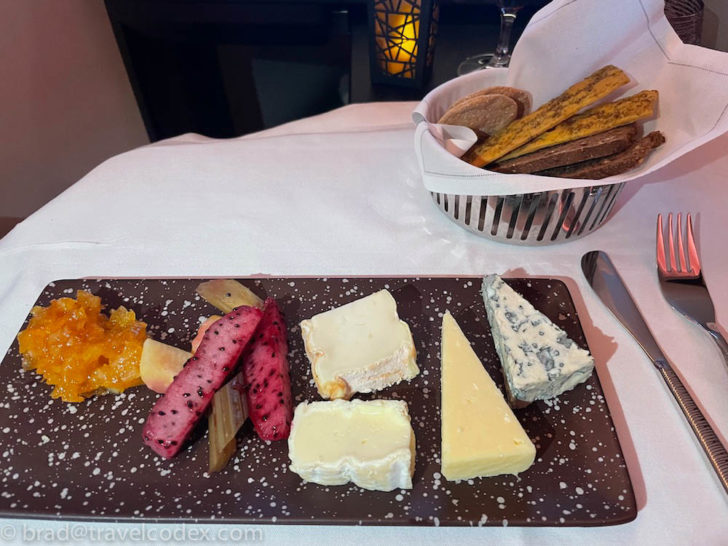 a plate of cheese and fruit on a table