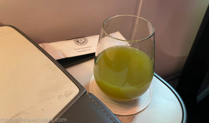 a glass of green liquid on a table