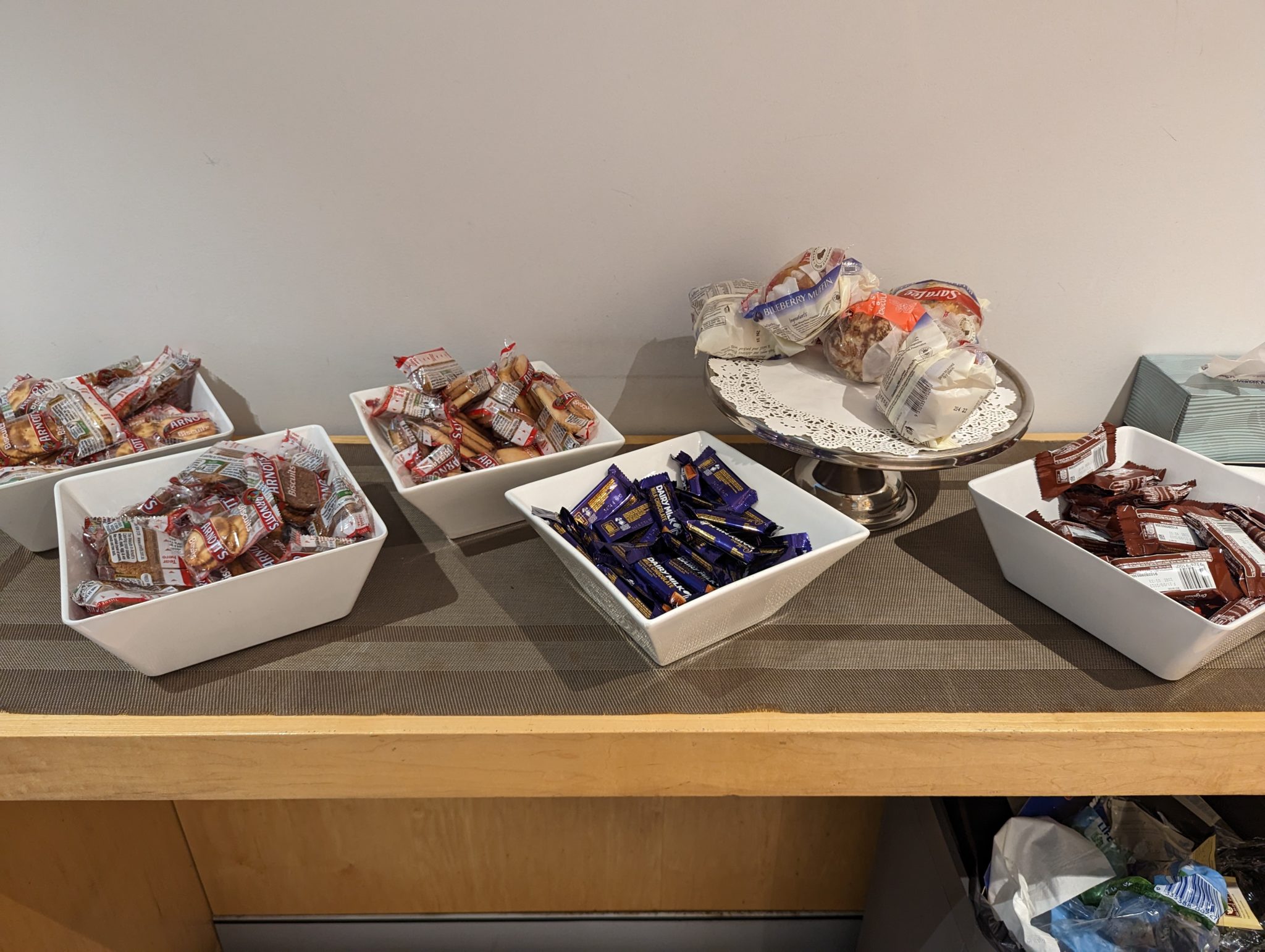 a group of white bowls of candy on a table