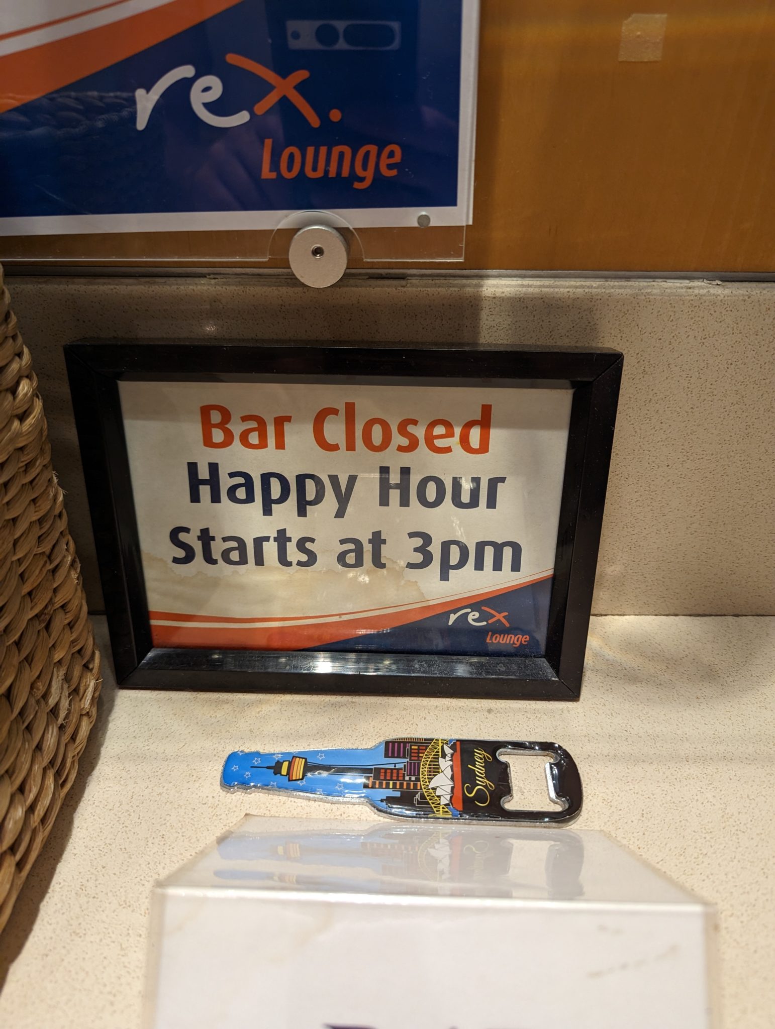 a sign and bottle opener on a counter