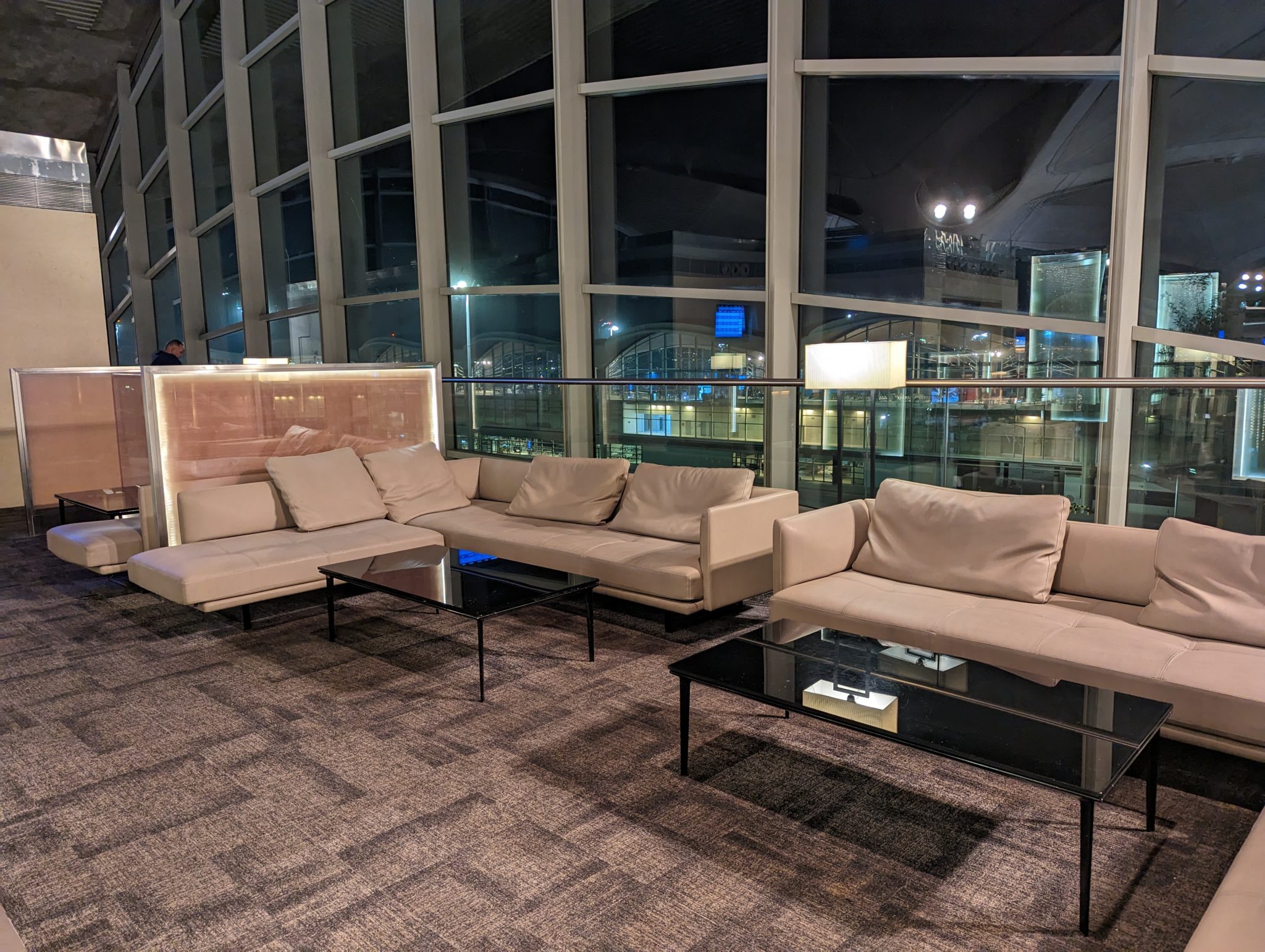 a couches and coffee tables in a room with large windows