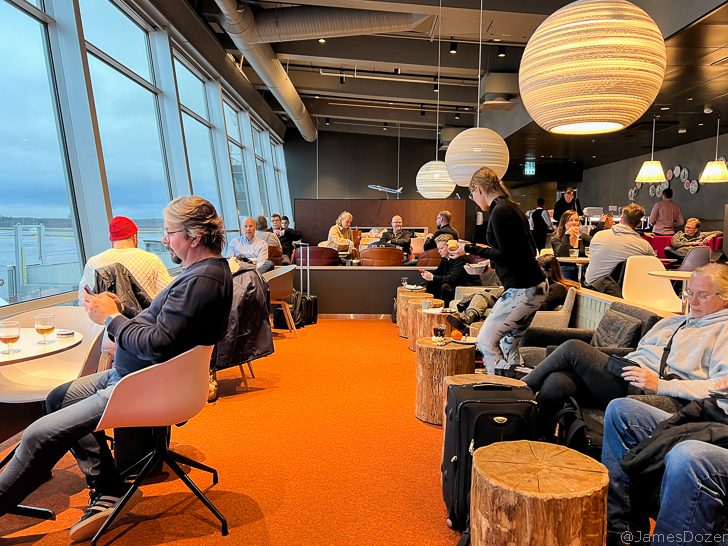 a group of people sitting in chairs in a room with large windows