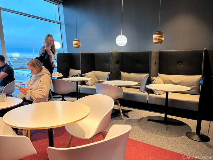 a woman standing in a room with tables and chairs