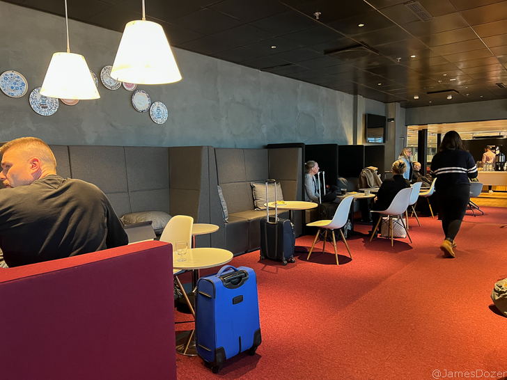a group of people sitting in a room with chairs and tables