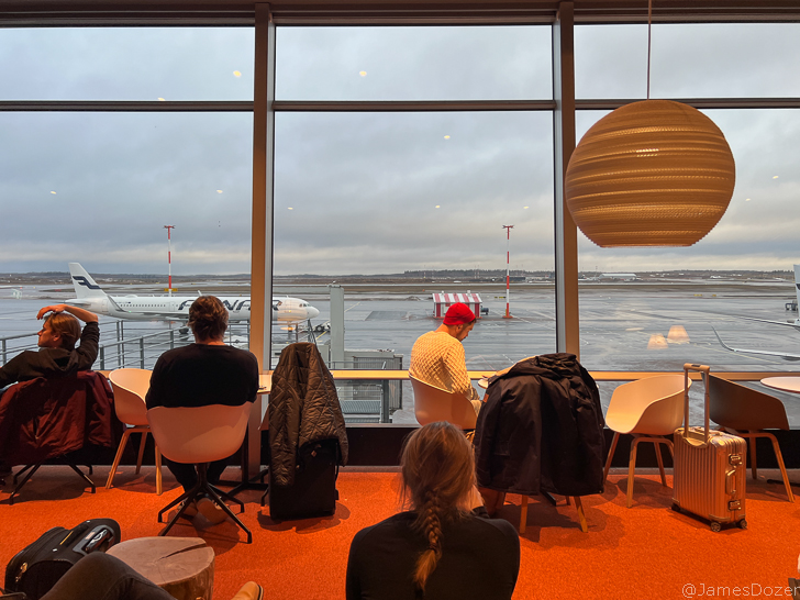 people sitting in chairs in front of a large window