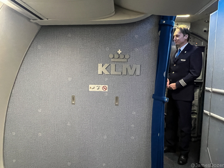 a man in uniform standing in an airplane