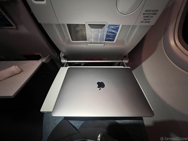 an open laptop on an airplane seat