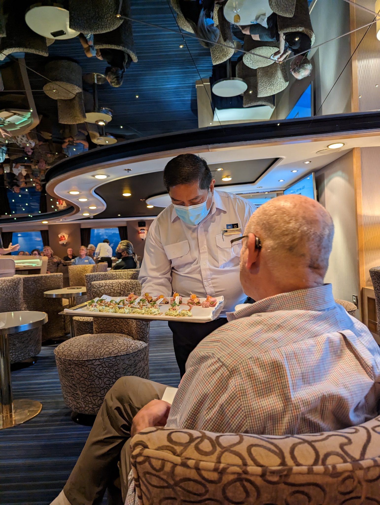 a man wearing a mask and holding a tray of food
