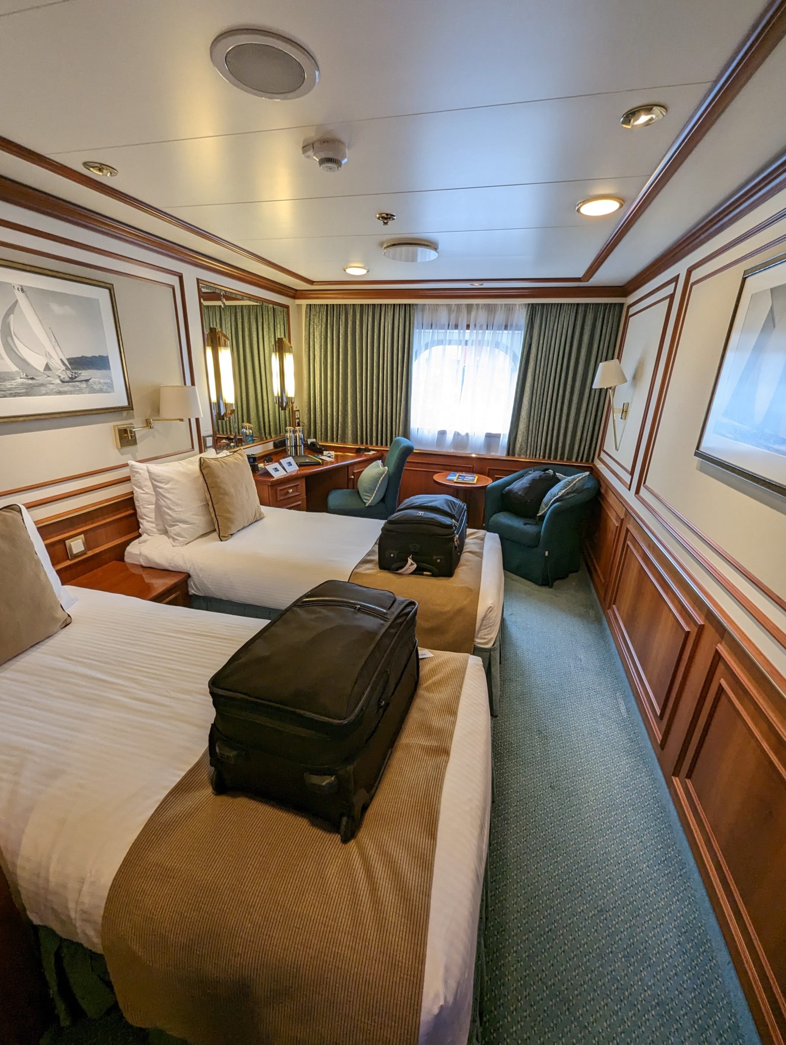 a room with two beds and a suitcase